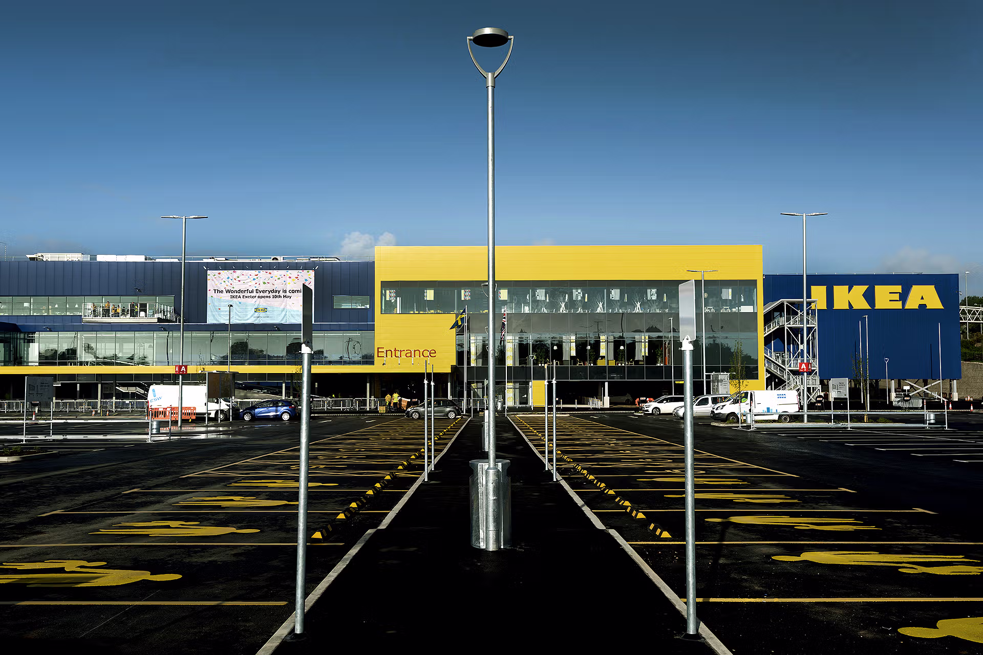 Front exterior of IKEA Exeter, showing the blue-and-yellow store, main entrance, opening announcement banner and car park.