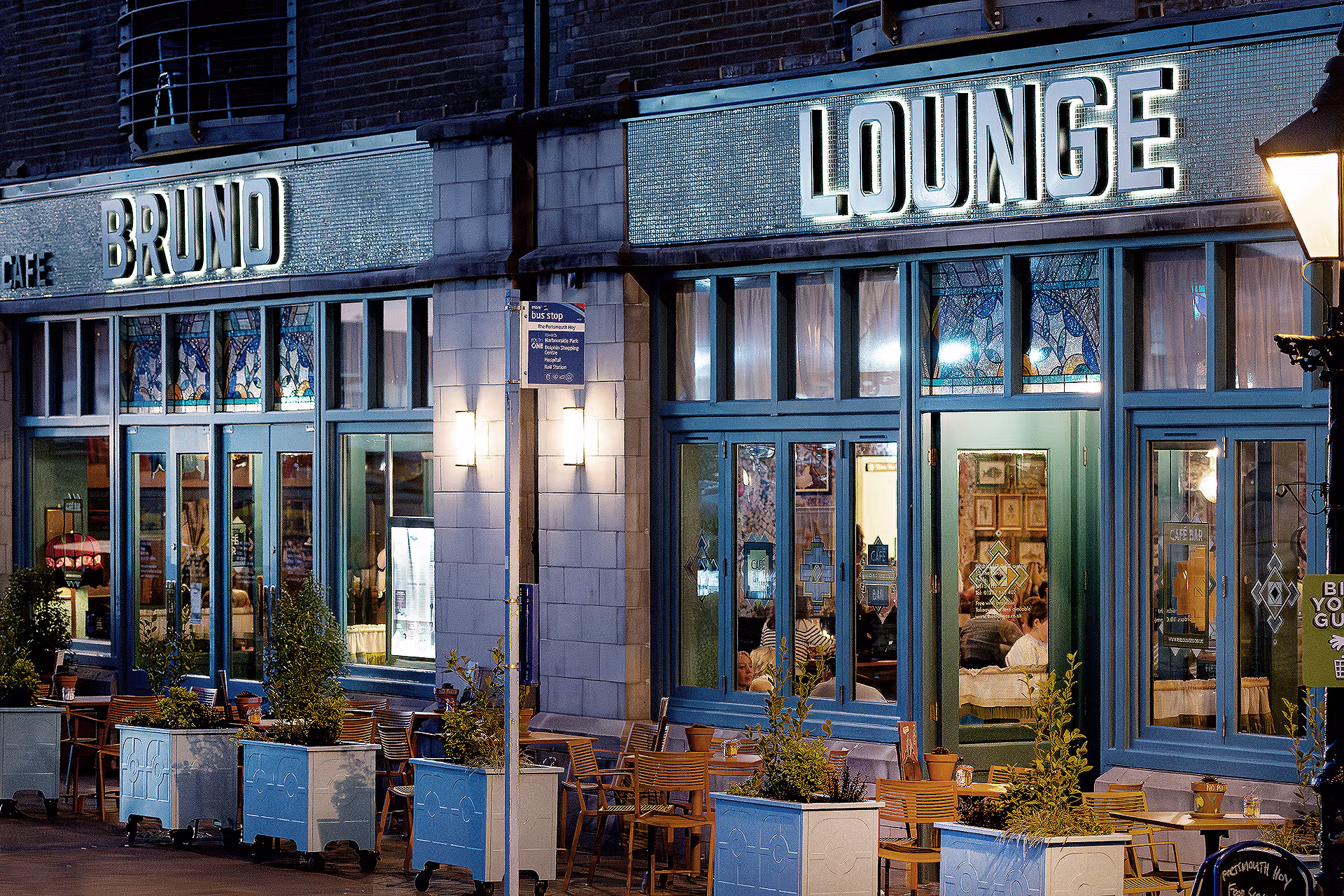 Loungers multi-location photography: Bruno Lounge in Poole at twilight, with illuminated signage, stained-glass windows and outdoor seating.